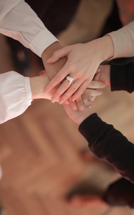 Friends stacking hands together in support